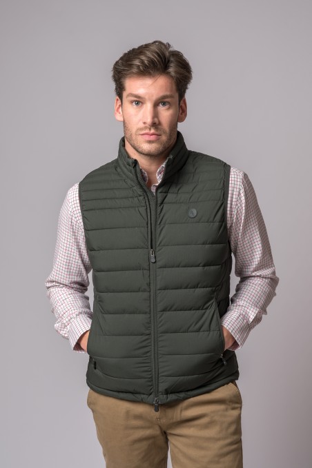 Homem com colete acolchoado verde escuro e camisa xadrez clara