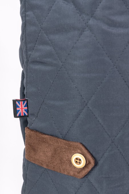 Casaco azul escuro acolchoado com botão castanho e etiqueta da bandeira do Reino Unido