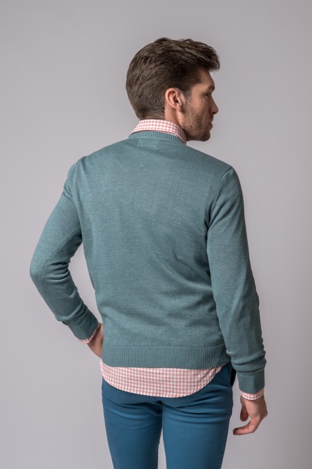 Homem de costas a usar suéter azul esverdeado e camisa rosa xadrez