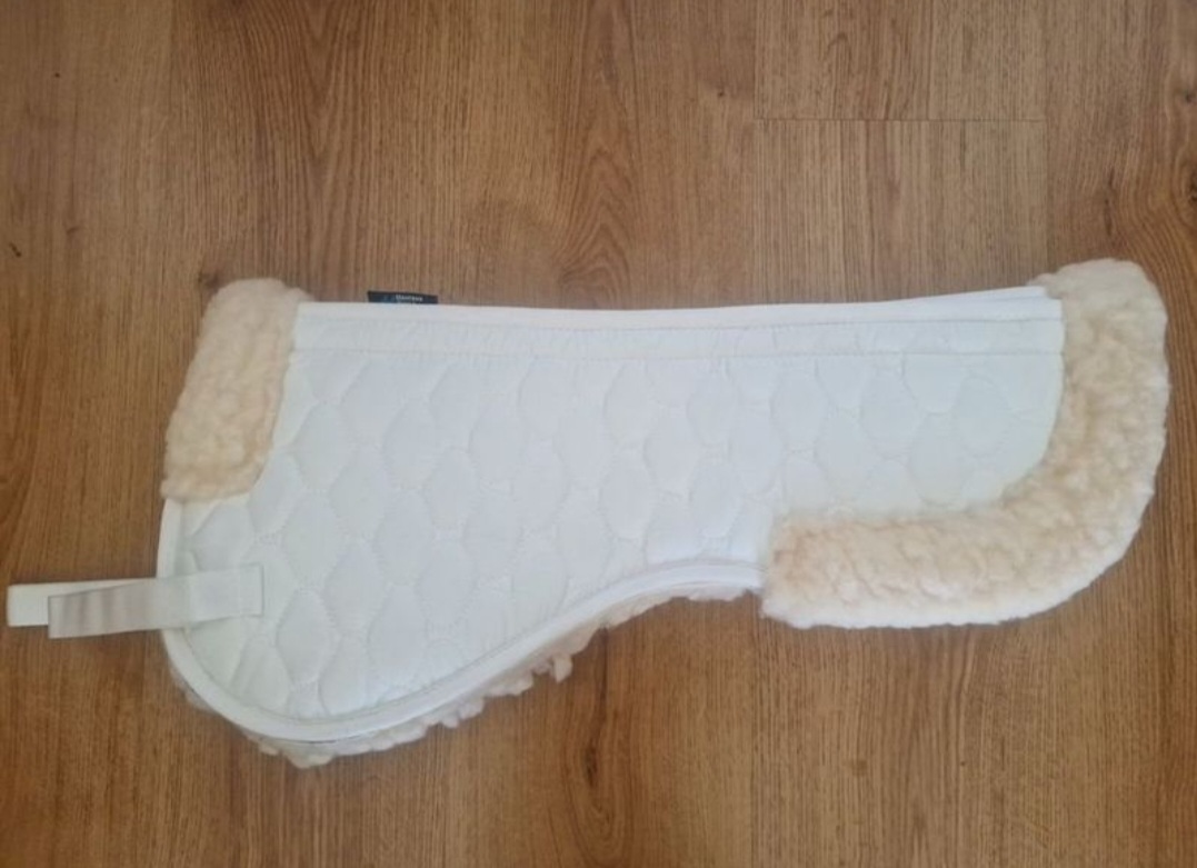 Protector de sela branco acolchoado com rebordos peludos beige