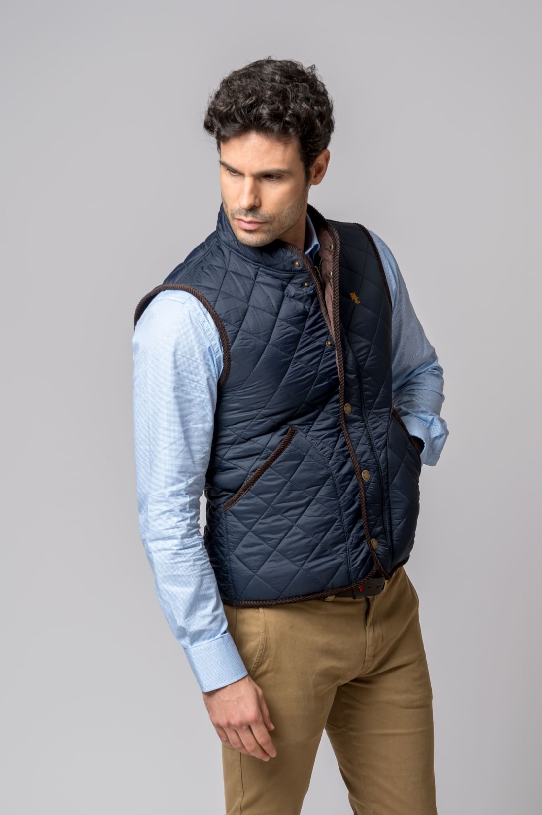 Homem com colete acolchoado azul escuro e camisa azul clara