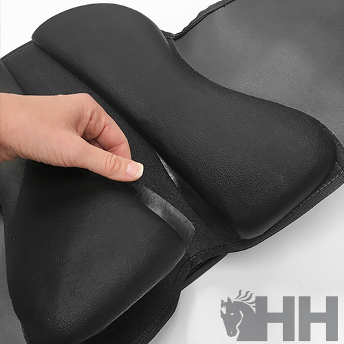 Produto acolchoado preto com superfície lisa e velcro, mão segurando aba, fundo branco e logótipo HH com cavalo