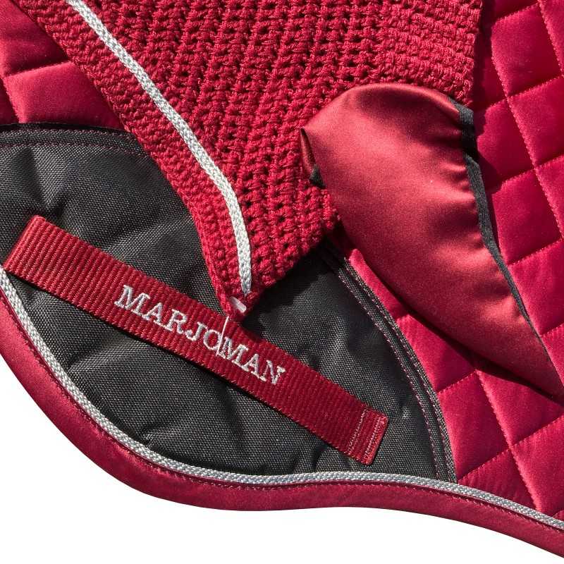 Produto têxtil vermelho acolchoado com faixa refletora e cinta elástica com texto MARJOMAN