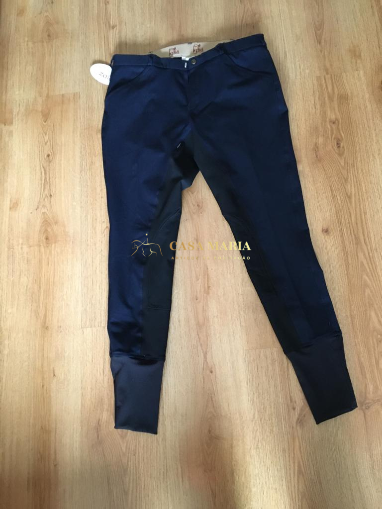 Calças de montar azul marinho com reforço nos joelhos e parte inferior das pernas em chão de madeira clara.