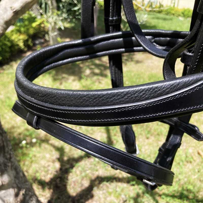 Peça de arreio de cavalo em couro preto com costuras brancas ao ar livre