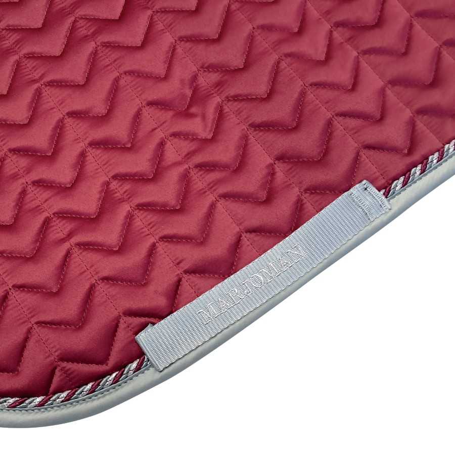 Tampo acolchoado vermelho com padrão zig-zag e etiqueta MARJOMLAN