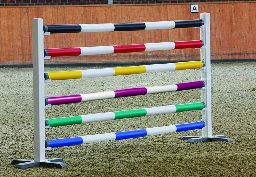 Estrutura de salto de equitação colorida com varões em branco e outras cores, base branca e chão de areia