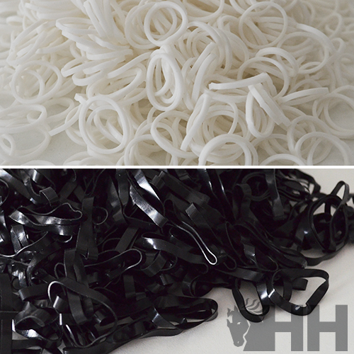Elásticos finos de silicone brancos e pretos sobre superfícies neutras