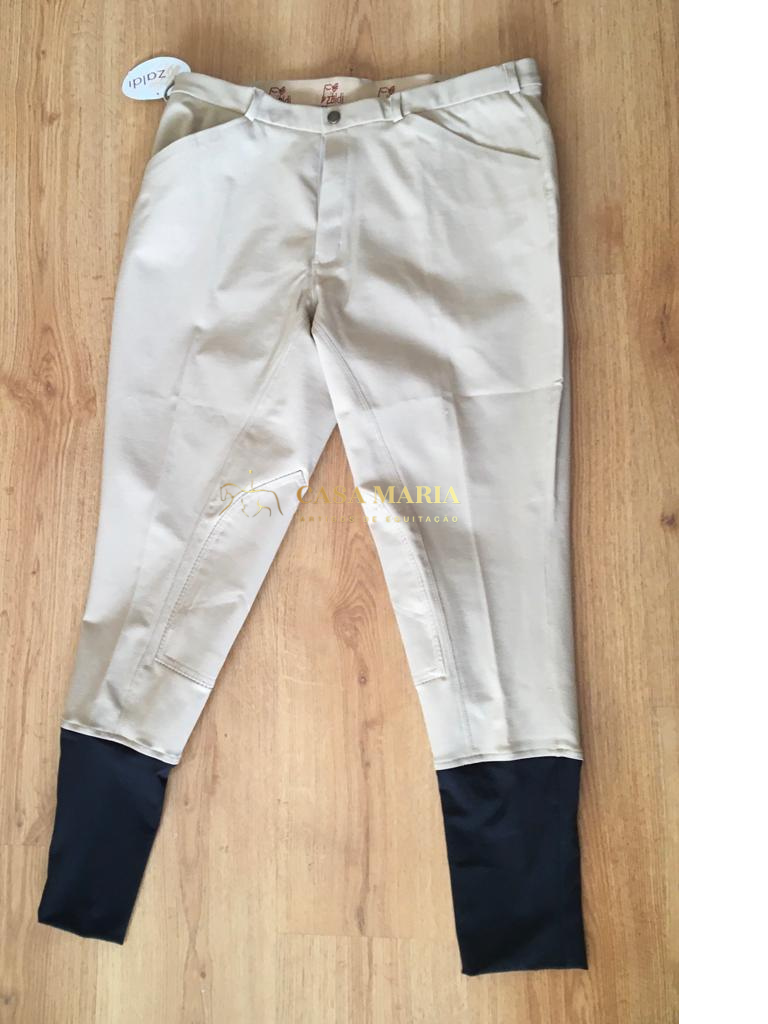 Calças de equitação bege com parte inferior preta sobre chão de madeira