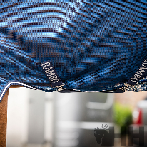 Cobertura azul para cavalo com etiquetas RAMBO e fundo desfocado