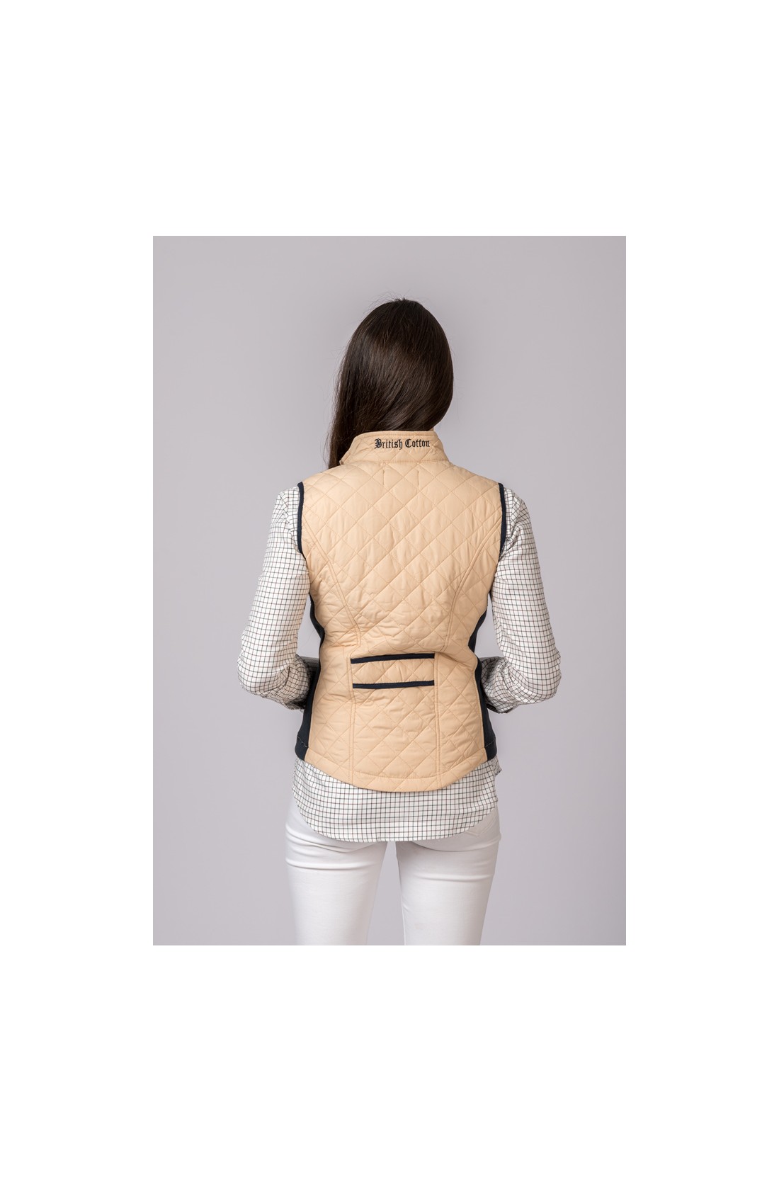 Colete acolchoado bege com bolsos e texto 'British Cotton' na gola visto de costas