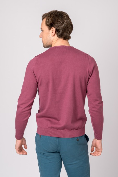 Homem de costas com camisola rosa e calças azuis