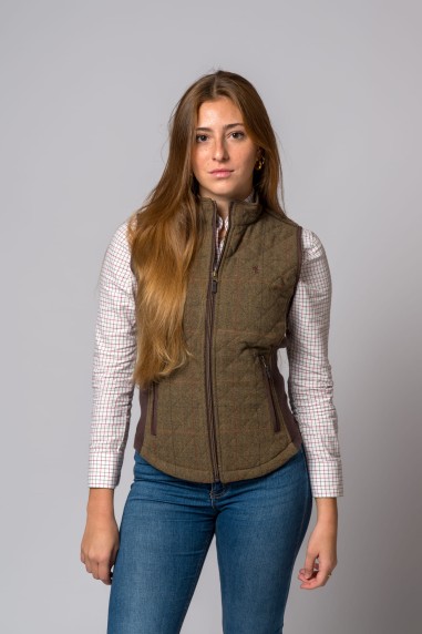 Colete acolchoado castanho com padrão de losangos e fecho de correr frontal usado por mulher