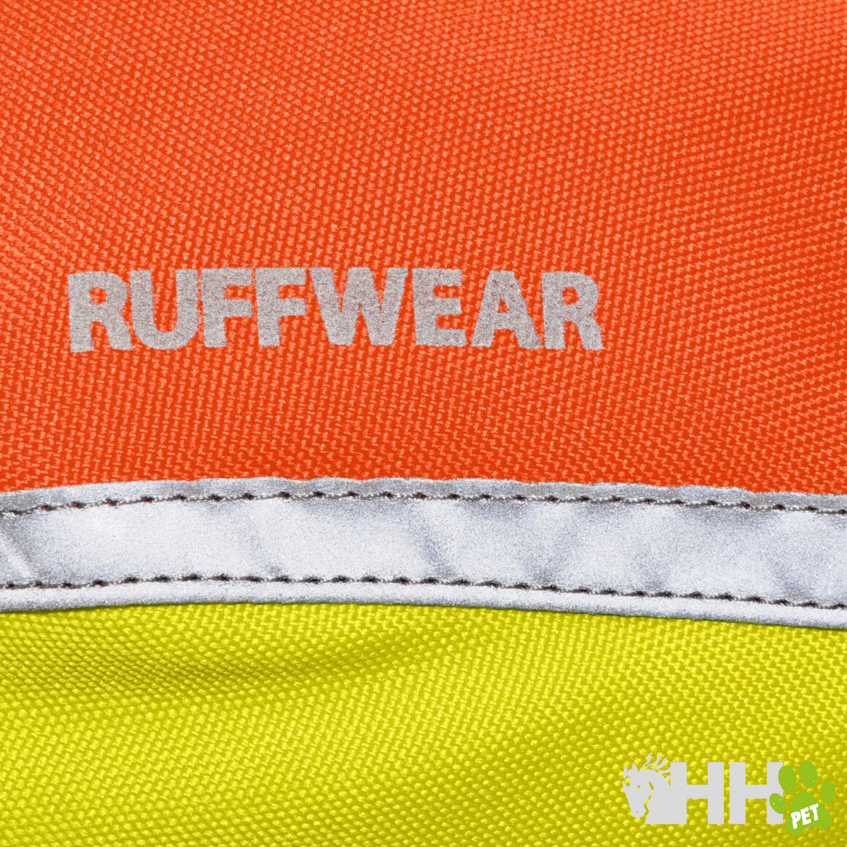 Detalhe de tecido laranja e amarelo com a palavra RUFFWEAR e faixa refletora cinza