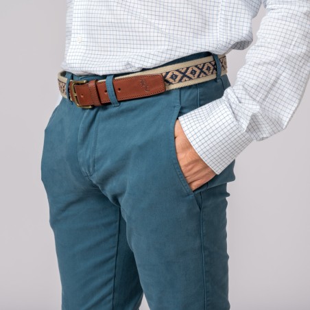 Pessoa com calças azuis, camisa branca xadrez e cinto bege com padrão azul escuro