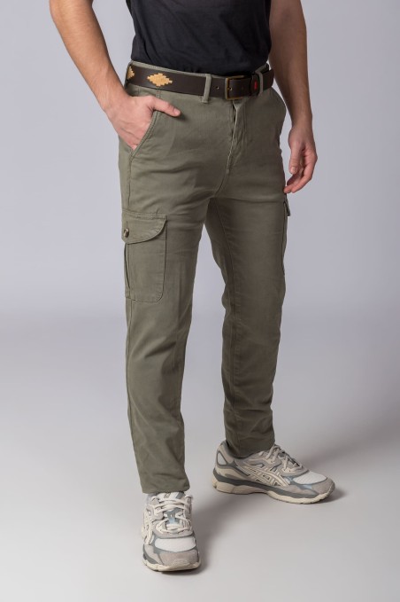 Homem a usar calças cargo verdes com bolsos laterais, cinto castanho com padrão e ténis desportivos brancos e cinza.