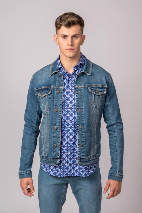 Homem com casaco de ganga azul e camisa azul estampada