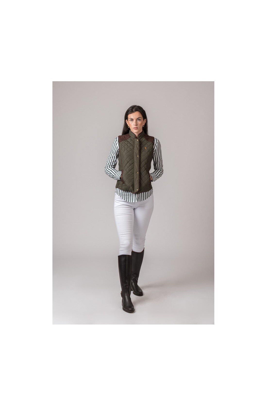 Mulher com colete verde militar acolchoado e botas pretas