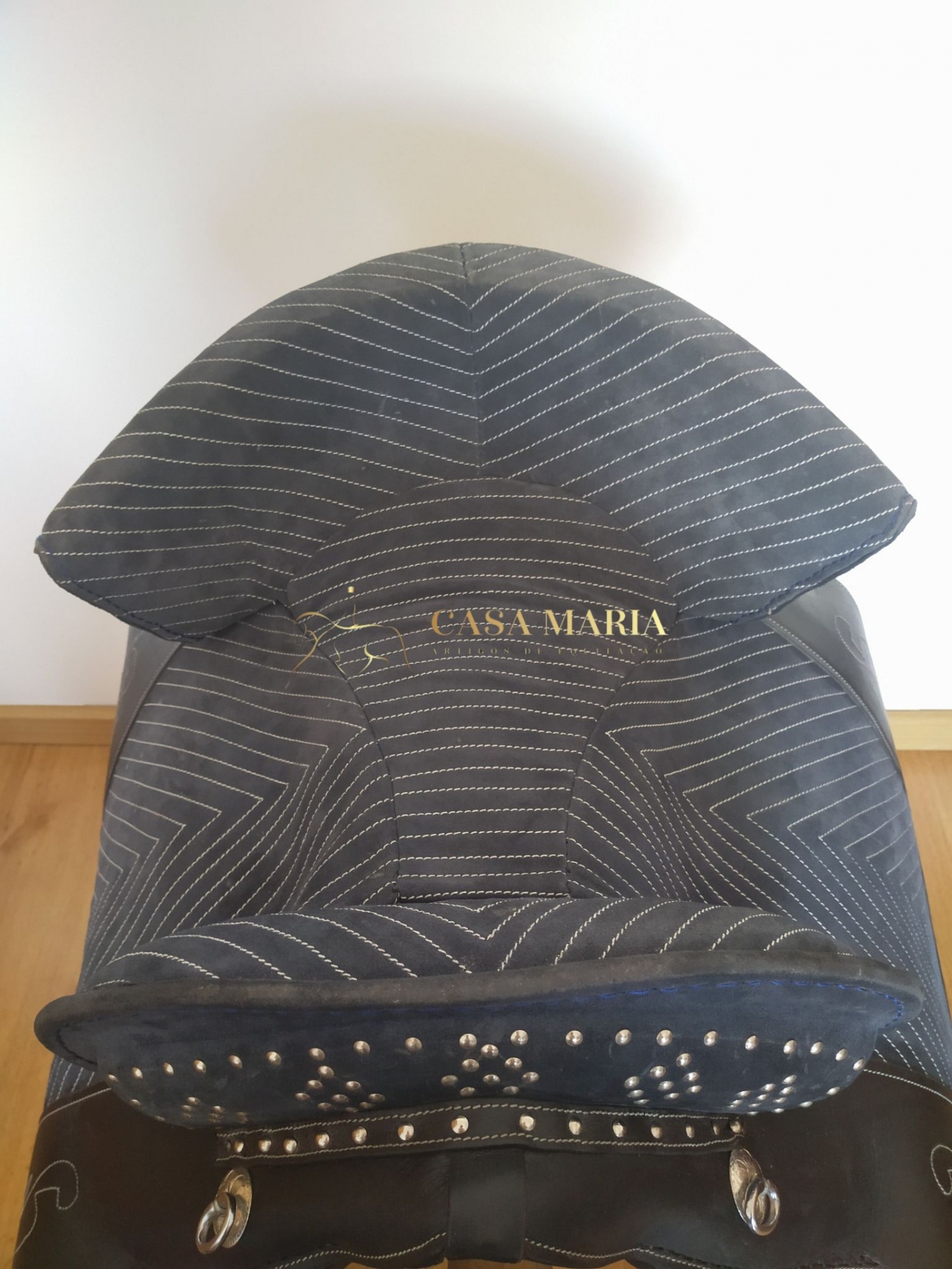 Sela de cavalo preta com costuras brancas e texto 'CASA MARIA' em dourado