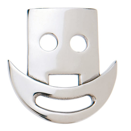 Objeto metálico prateado em forma de face sorridente com dois buracos redondos e recorte inferior