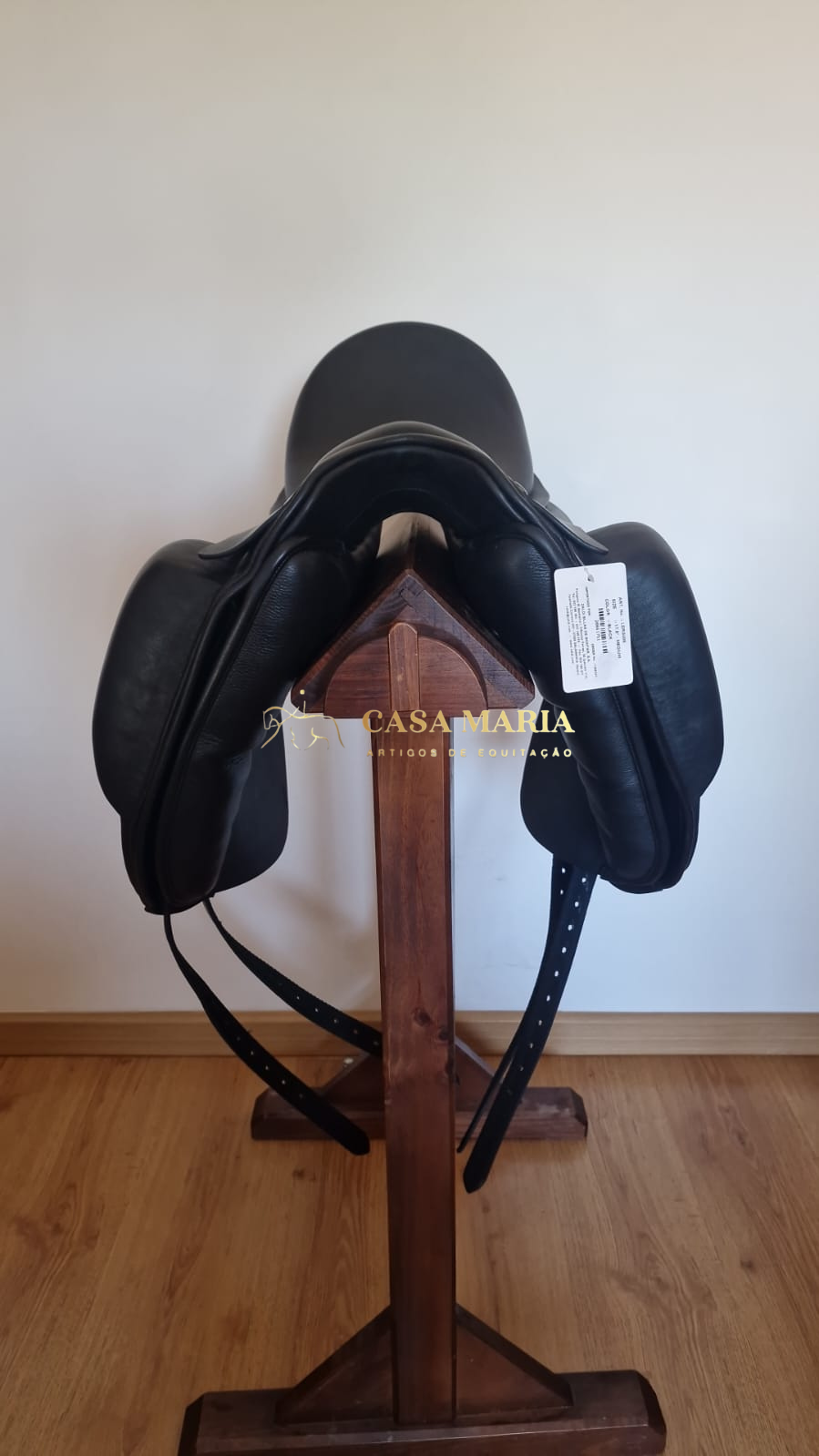 Sela de equitação preta em suporte de madeira