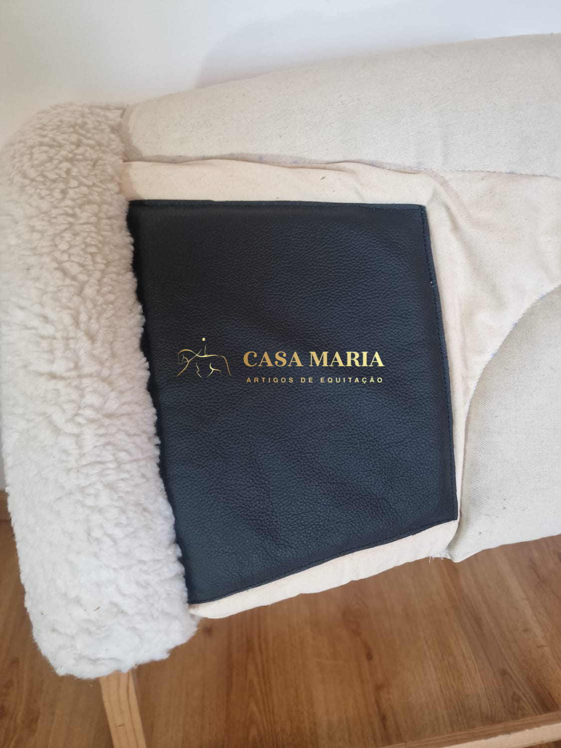 Saco preto em pele sintética sobre enchimento bege com forro de pele sintética branca