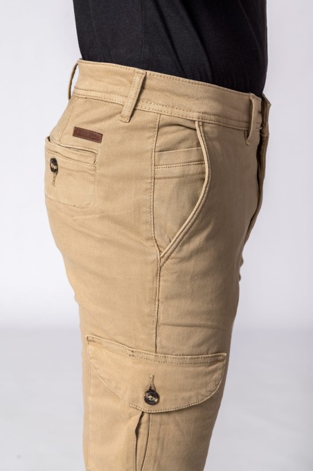 Calças beige com bolsos e botões escuros usadas por uma pessoa