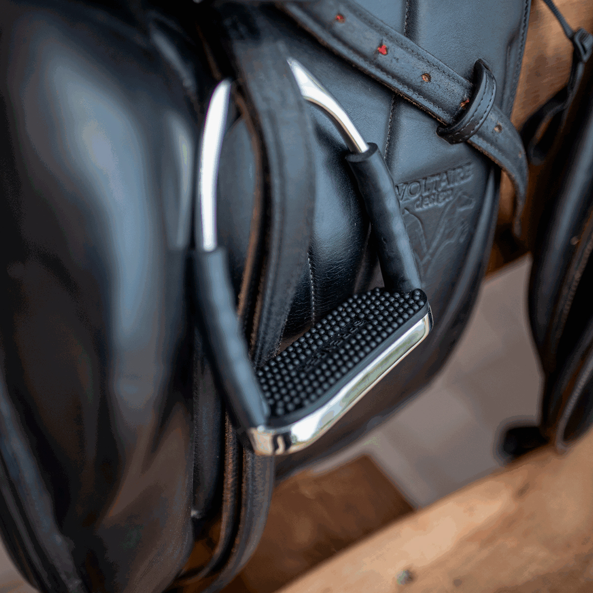 Espora de equitação em metal prateado com armação preta texturizada em arreio de couro preto com gravações