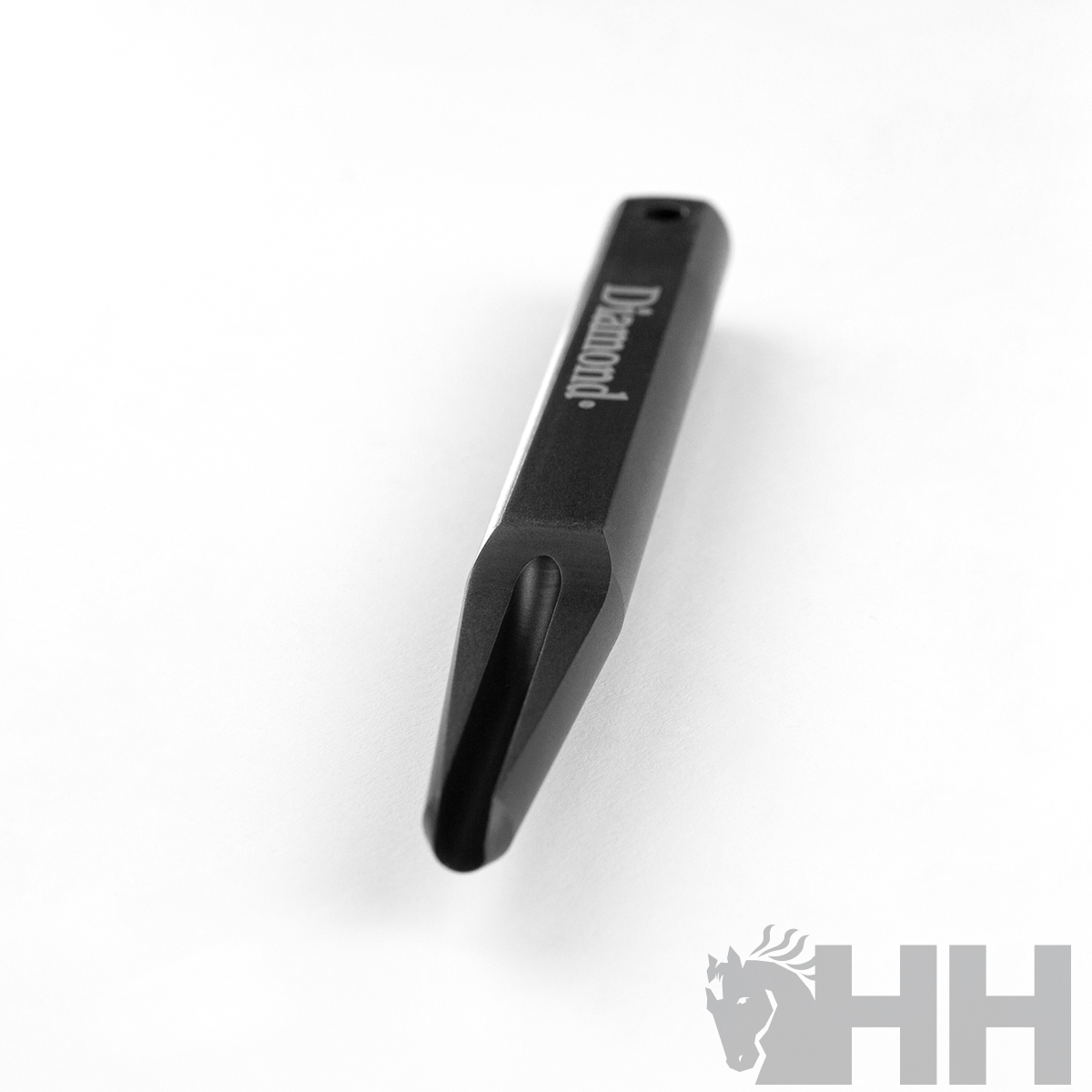 Peça metálica preta com inscrição 'Diamond' sobre fundo branco