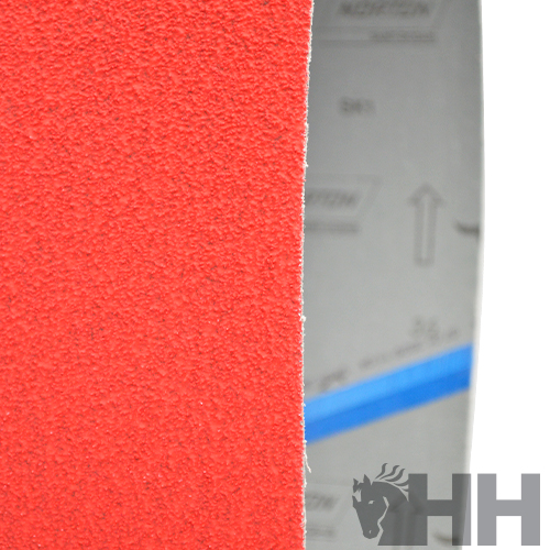 Bloco de lixa vermelho com textura granulada e embalagem ao fundo