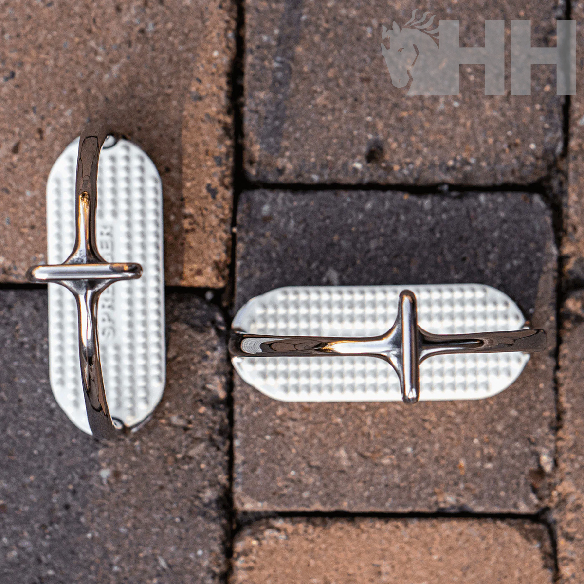 Puxadores metálicos cromados sobre superfície de blocos de pavimentação