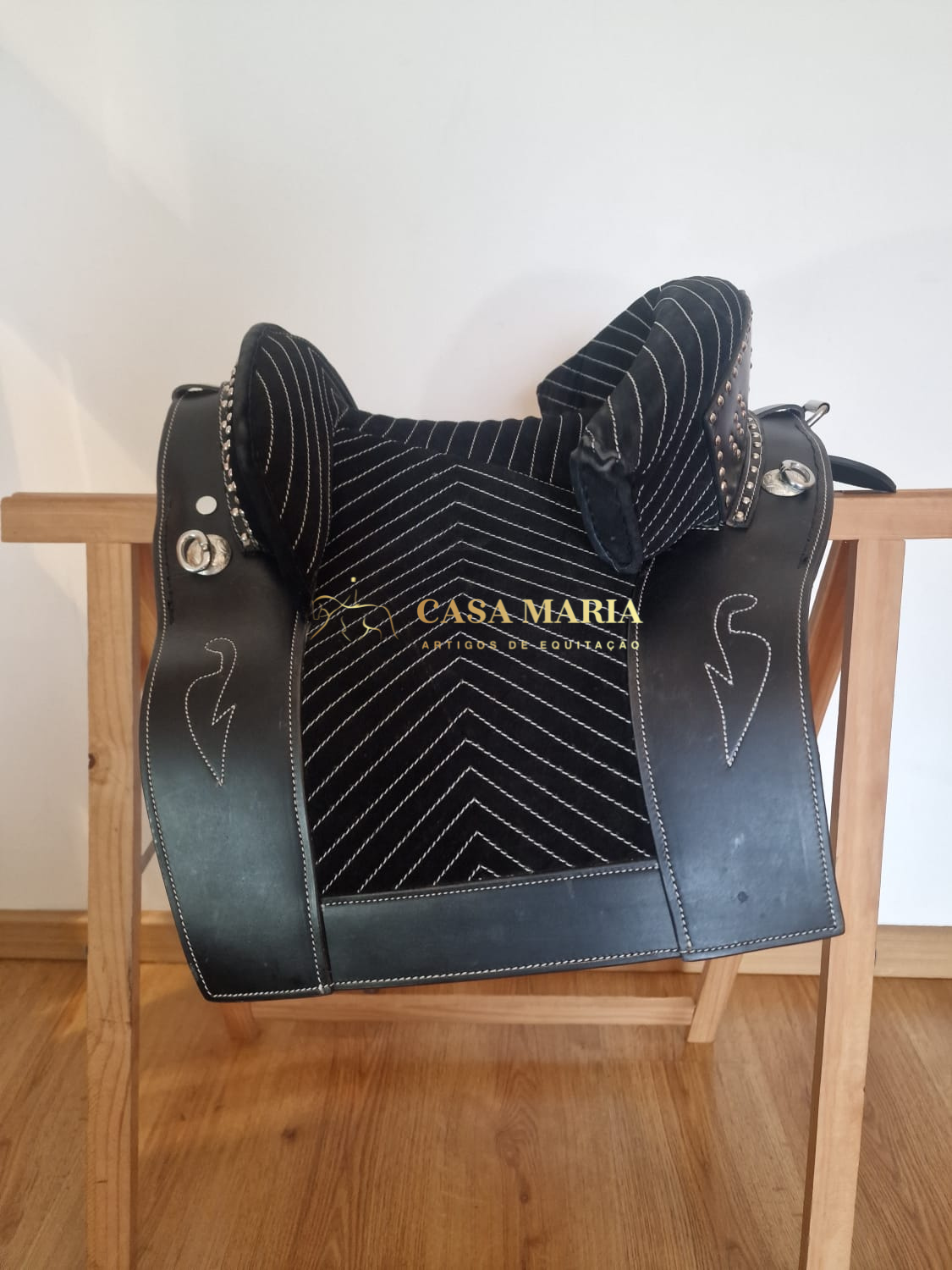 Sela de montaria preta em couro com bordados e texto Casa Maria