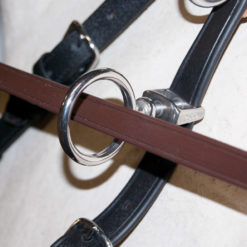 Pormenor de sela de equitação em pele marrom e preta com fivelas e argolas metálicas