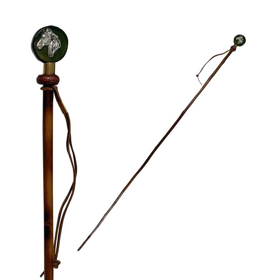 Chicote castanho com punho decorado com cabeça de cavalo prateada e anilha vermelha