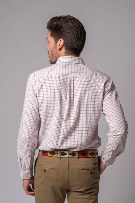 Homem de costas vestindo camisa xadrez branca com vermelho e azul e calças castanhas com cinto colorido.