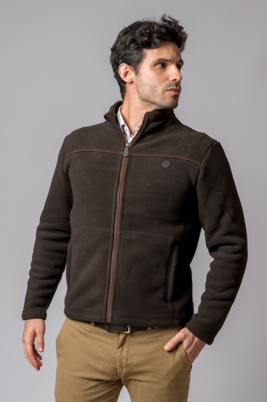 Casaco castanho escuro de homem com fecho de correr e bolsos, vestindo calças beges