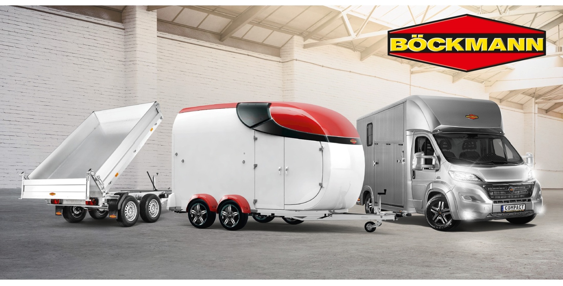 Dois reboques Böckmann ligados a uma carrinha cinza em armazém