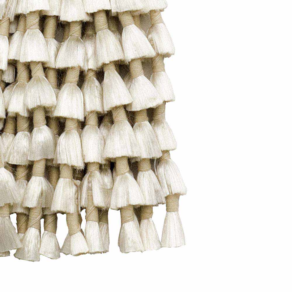 Franjas de tecido branco amarradas com fio bege em camadas