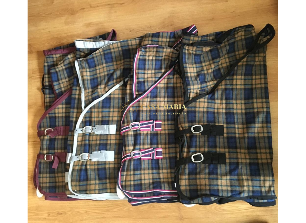 Mantas para cavalos xadrez com cintas e fivelas sobre chão de madeira