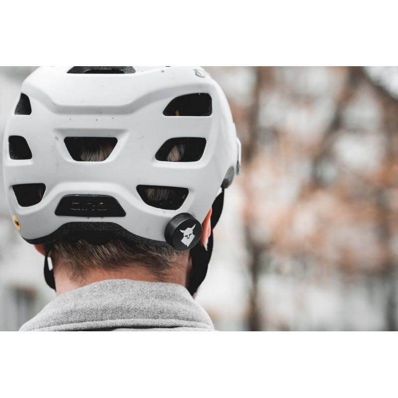 Capacete de bicicleta branco com dispositivo preto e símbolo branco na parte traseira