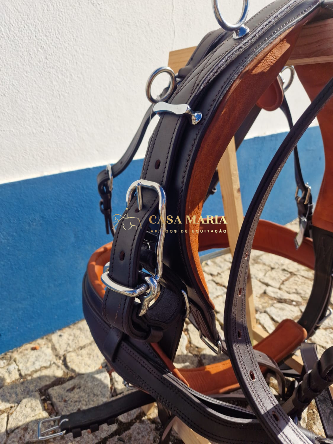 Peitoral de equitação castanho escuro com metal prateado em cenário exterior