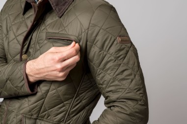 Casaco acolchoado verde musgo com zíper no bolso do peito e etiqueta no braço