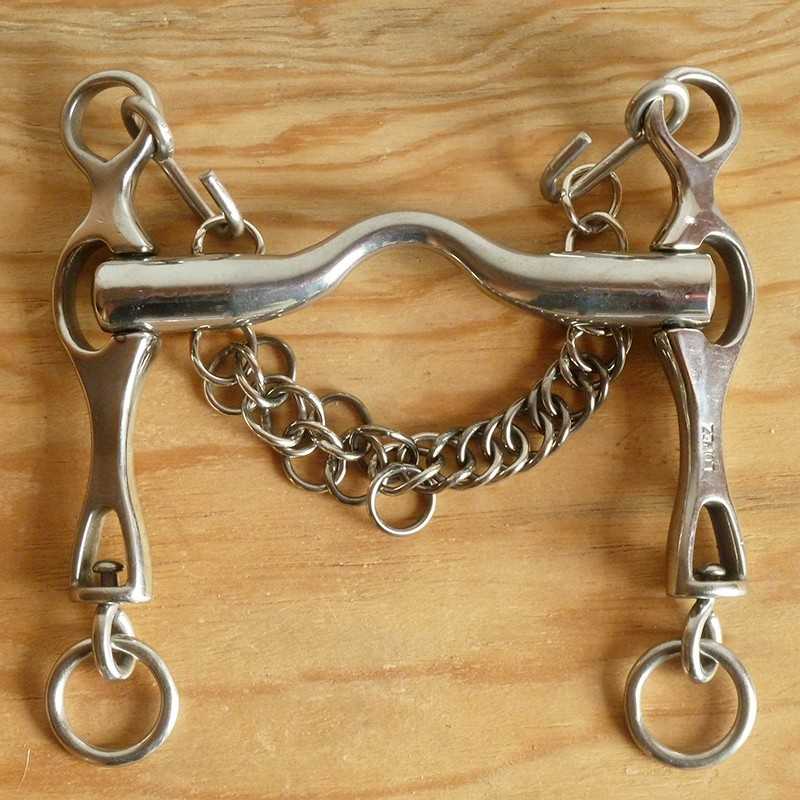 Freio de metal prateado com corrente sobre madeira clara