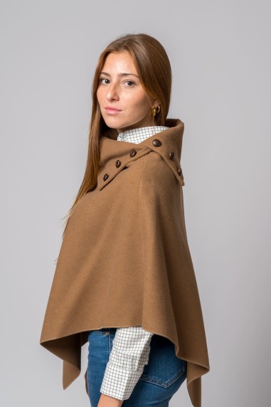 Mulher de perfil com capa castanha e camisa xadrez