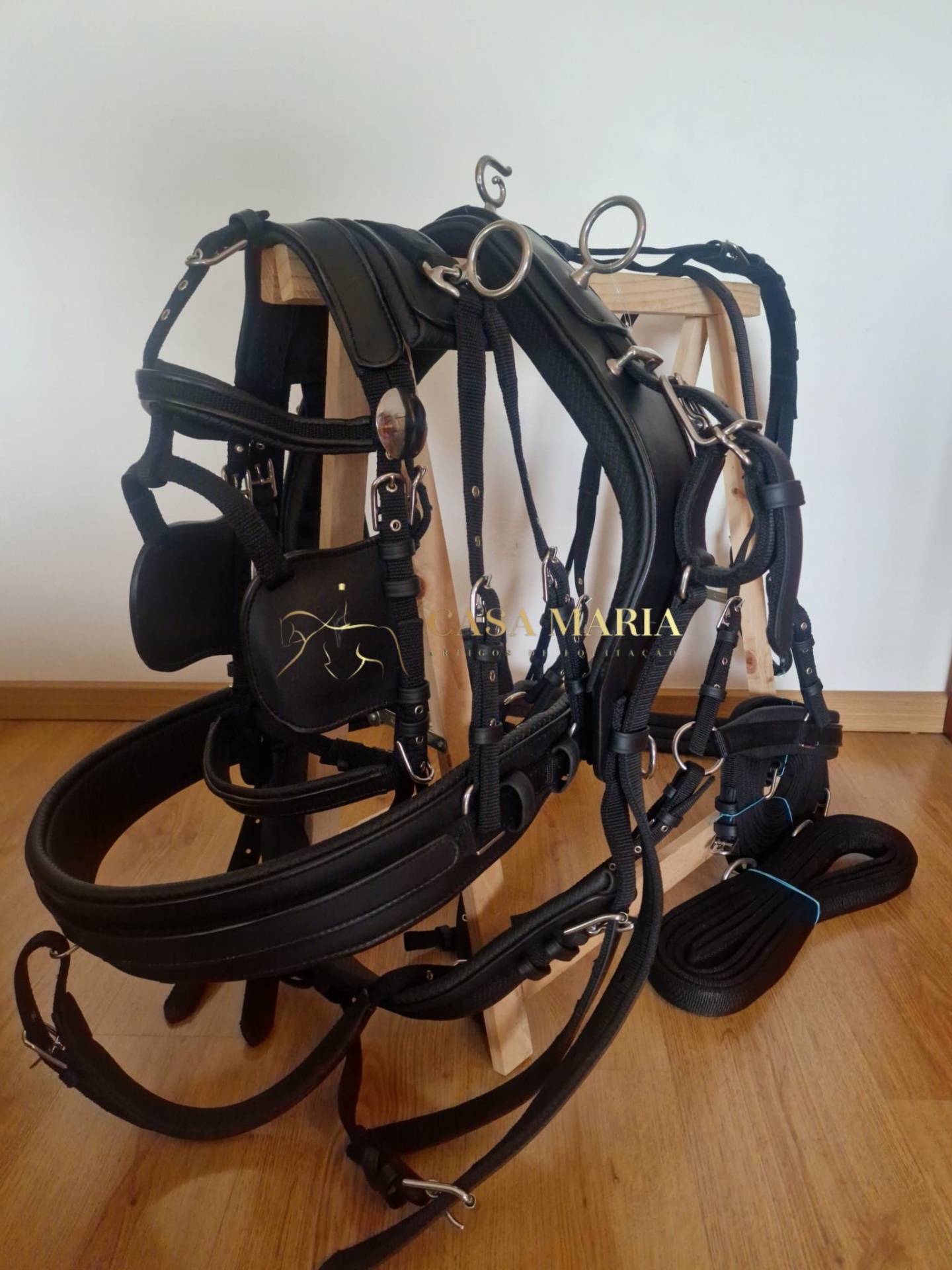Arnês e acessórios de equitação em couro preto com fivelas metálicas