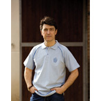 Homem com pólo azul claro e gola azul escuro em ambiente exterior