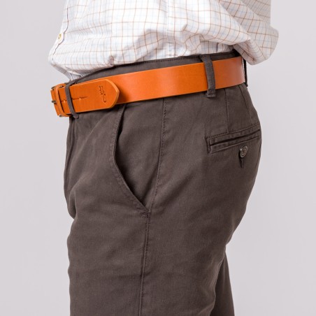 Cinto de pele castanha clara com fivela metálica usado com calças castanhas escuras