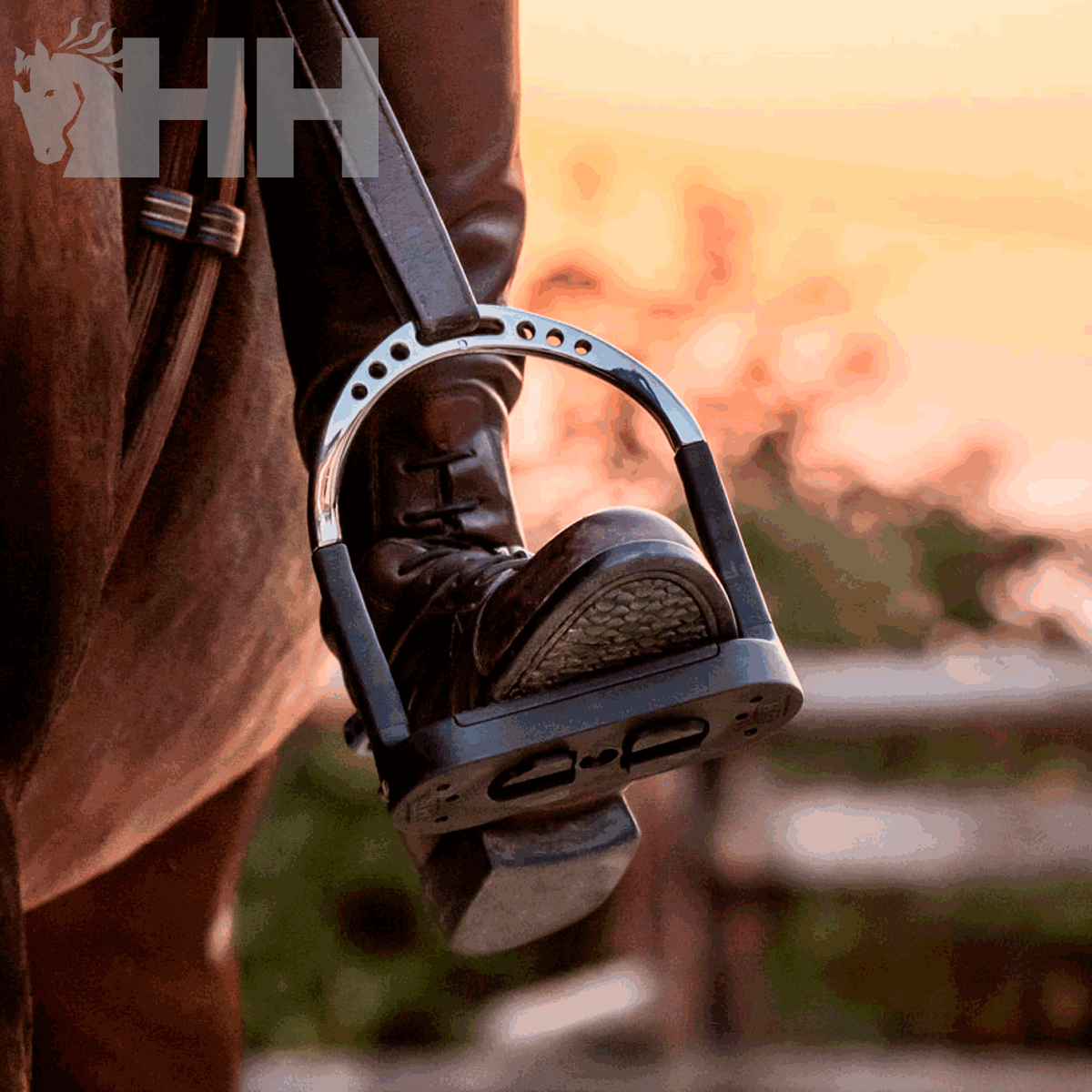 Bota de equitação com espora prata montada em cavalo castanho ao entardecer