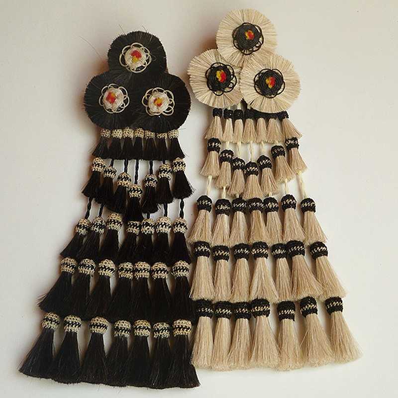 Brincos compridos de franjas pretas e brancas com motivos florais no topo