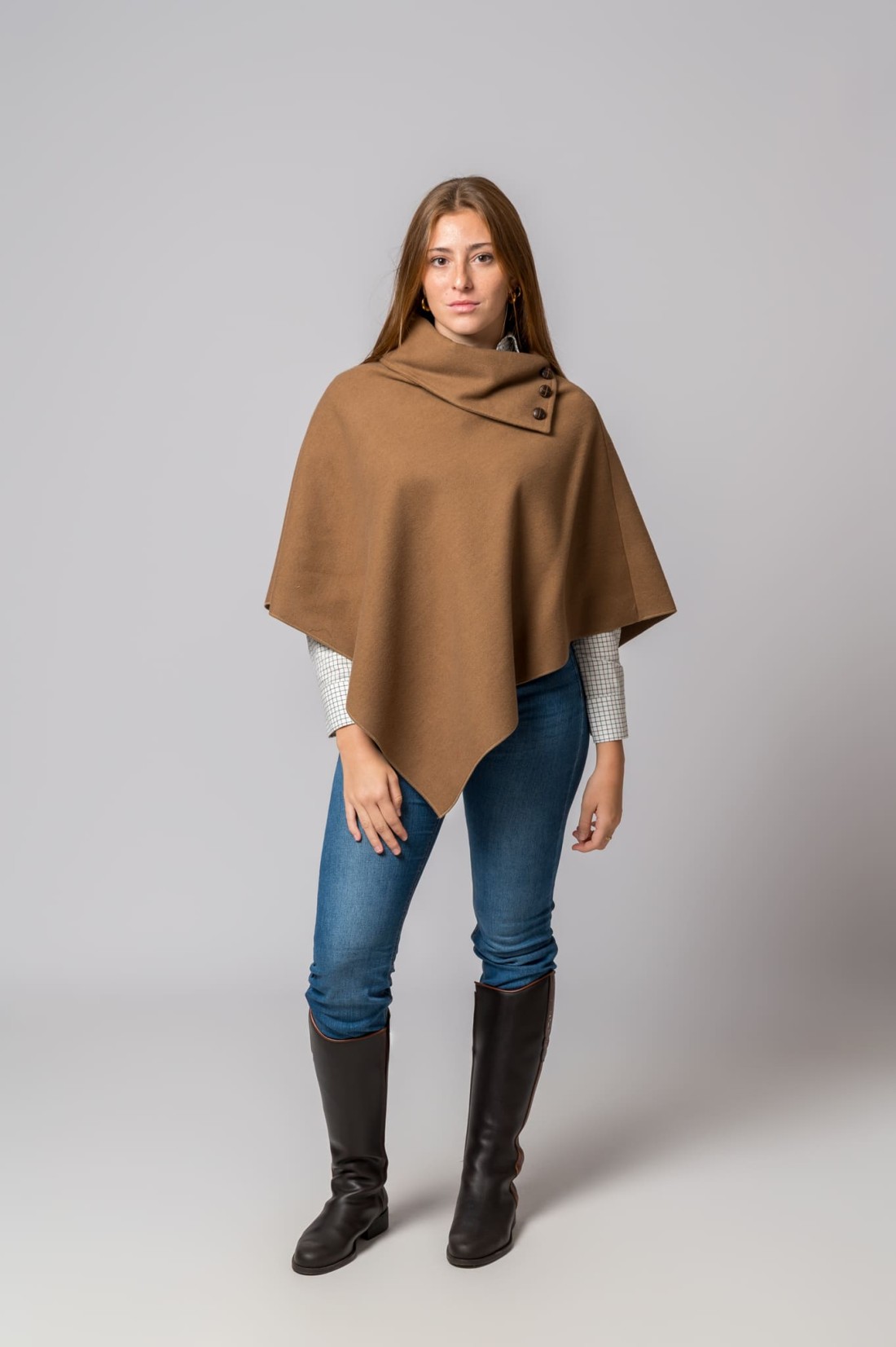 Mulher com capa castanha e botas pretas de couro